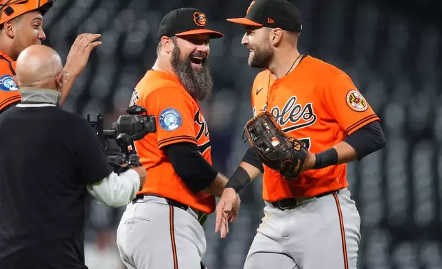 Baltimore Orioles pitcher Andrew Kittredge, left, congratulates center fielder Colton Cowser after the Orioles defeated the Colorado Rockies in a baseball game Monday, Aug. 31, 2026, in Denver. (AP Photo/David Zalubowski)