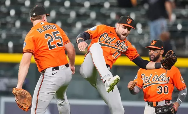Baltimore Orioles center fielder Colton Cowser, center, celebrates with first baseman Pete Alonso, left, and right fielder Leody Taveras after defeating the Colorado Rockies in a baseball game Monday, Aug. 31, 2026, in Denver. (AP Photo/David Zalubowski)