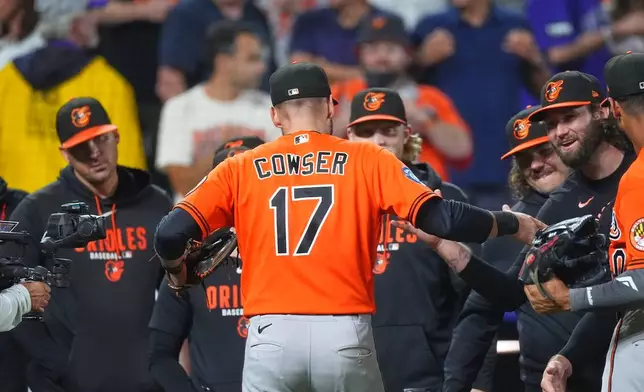 Baltimore Orioles center fielder Colton Cowser is congratulated by teammates after the Orioles' victory over the Colorado Rockies in a baseball game Monday, Aug. 31, 2026, in Denver. (AP Photo/David Zalubowski)