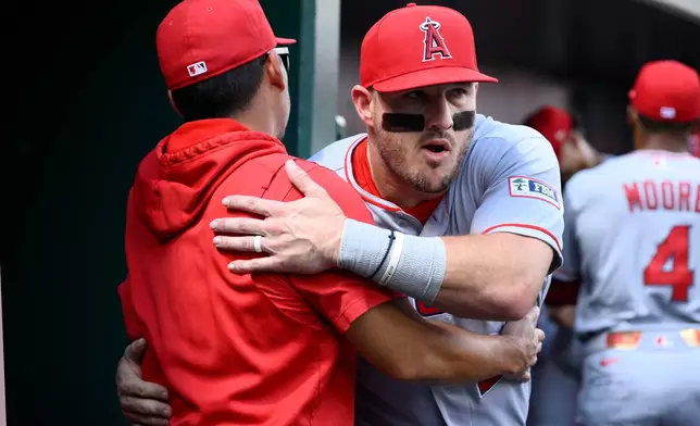 Los Angeles Angels' Mike Trout, right, and manager Kurt Suzuki, left, hug before a baseball game against the Washington Nationals, Sunday, Sept. 13, 2026, in Washington. (AP Photo/Nick Wass)