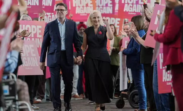 Britain's Prime Minister Andy Burnham and his wife Marie-France van Heel are greeted by supporters ahead of the Leaders Speech at the Labour Party Conference in Liverpool, England, Tuesday, Sept. 29, 2026. (AP Photo/Jon Super)