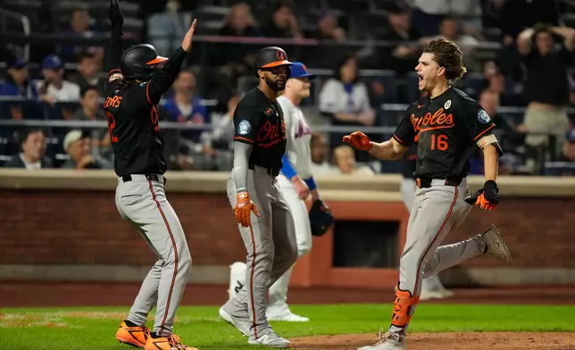 Baltimore Orioles' Coby Mayo, right, celebrates with Dylan Beavers, left, and Leody Taveras, center, after hitting a three-run home run during the eleventh inning of a baseball game against the New York Mets, Tuesday, Sept. 15, 2026, in New York. (AP Photo/Seth Wenig)