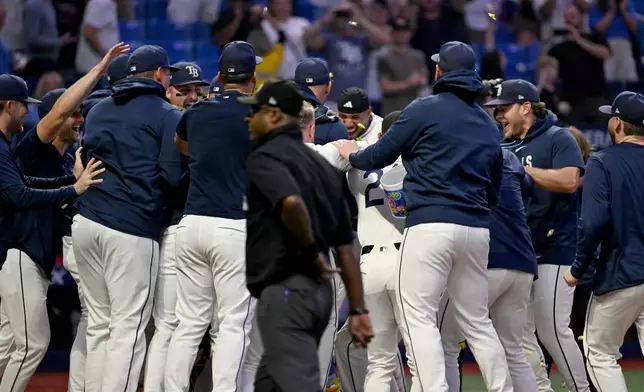 The Tampa Bay Rays celebrate Junior Caminero's walk-off home run during the ninth inning of a baseball game against the Athletics Tuesday, Sept. 15, 2026, in St. Petersburg, Fla. (AP Photo/Jason Behnken)