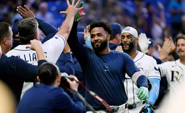 Tampa Bay Rays' Junior Caminero, center, celebrates his walk-off home run during the ninth inning of a baseball game against the Athletics Tuesday, Sept. 15, 2026, in St. Petersburg, Fla. (AP Photo/Jason Behnken)