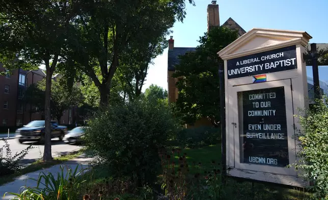 A sign denouncing surveillance is seen outside University Baptist Church, Friday, Sept. 4, 2026, in Minneapolis. (AP Photo/Ellen Schmidt)