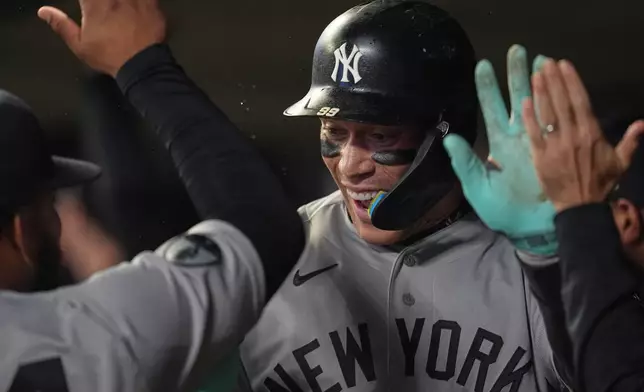 New York Yankees' Aaron Judge celebrates in the dugout after hitting a three-run home run during the eighth inning of a baseball game against the Minnesota Twins, Monday, Sept. 14, 2026, in Minneapolis. (AP Photo/Abbie Parr)