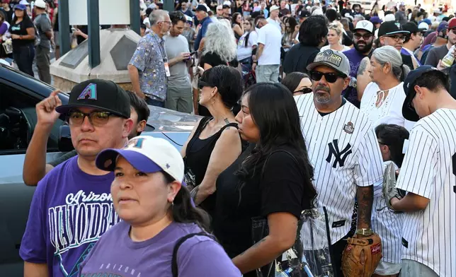 Arizona Diamondbacks and New York Yankees fans wait for the ballpark gates to open prior to a baseball game, Saturday, Sept. 19, 2026, in Phoenix. (AP Photo/Caitlin O'Hara)