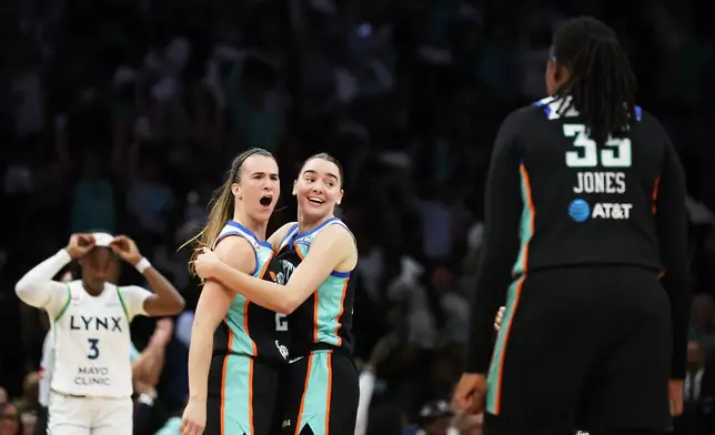 New York Liberty guard Sabrina Ionescu, left, reacts with teammates Pauline Astier, center, and Jonquel Jones (35) after scoring a three-point basket during the first half of Game 2 of a WNBA basketball first-round playoff series against the Minnesota Lynx, Tuesday, Sept. 29, 2026, in New York. (AP Photo/Heather Khalifa)
