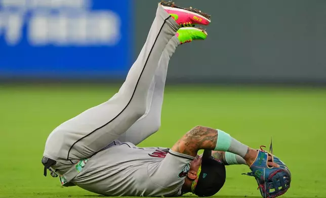 Arizona Diamondbacks second baseman Ketel Marte falls backwards after catching a line drive for the out on Kansas City Royals' Carter Jensen during the third inning of a baseball game, Tuesday, Sept. 8, 2026, in Kansas City, Mo. (AP Photo/Charlie Riedel)