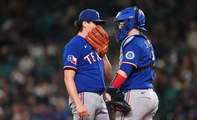 Texas Rangers starting pitcher Cal Quantrill talks with catcher Danny Jansen, right, during the fourth inning of a baseball game against the Seattle Mariners, Tuesday, Sept. 8, 2026, in Seattle. (AP Photo/Lindsey Wasson)