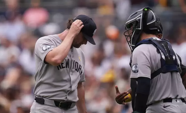 New York Yankees starting pitcher Gerrit Cole, left, talks with Austin Wells after giving up three home runs during the first inning of a baseball game against the San Diego Padres Sunday, Sept. 6, 2026, in San Diego. (AP Photo/Gregory Bull)