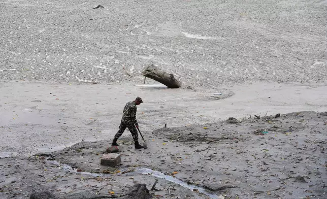 FILE - A policeman searches for bodies along the Trishuli River after flash floods in Nepal's Nuwakot district, Aug. 29, 2026. (AP Photo/Dar Yasin, FIle)