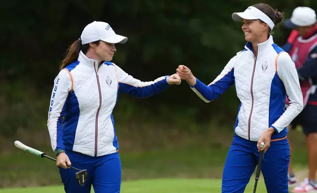 Leona Maguire, left, of Europe and teammate Esther Henseleit celebrate after winning the 11th hole during the Solheim Cup at the Bernardus Golf course in Den Bosch, Netherlands, Friday, Sept. 11, 2026. (AP Photo/Alastair Grant)