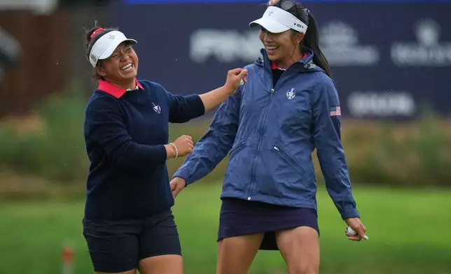 Megan Khang of the United States, left, celebrates with Alison Lee after sinking a putt on the 12th green during the Solheim Cup in Den Bosch, Netherlands, Friday, Sept. 11, 2026. (AP Photo/Alastair Grant)