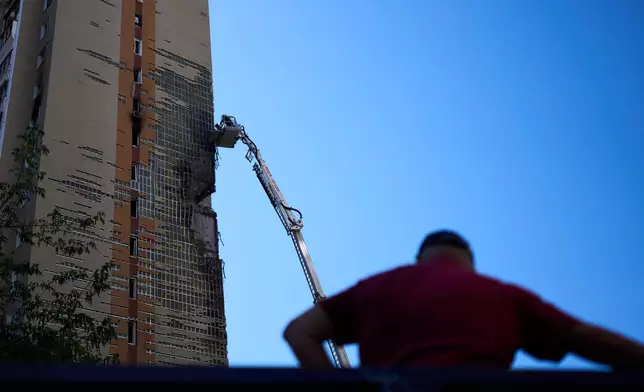 Firefighters work on a partially damaged residential building following a Russian drone attack in Kyiv, Ukraine, Wednesday, Sept. 9, 2026. (AP Photo/Francisco Seco)