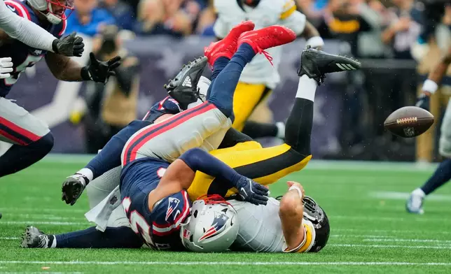 Pittsburgh Steelers quarterback Aaron Rodgers, right, is sacked by New England Patriots' Christian Elliss during the first half of an NFL football game against the New England Patriots, Sunday, Sept. 20, 2026, in Foxboro, Mass. (AP Photo/Charles Krupa)