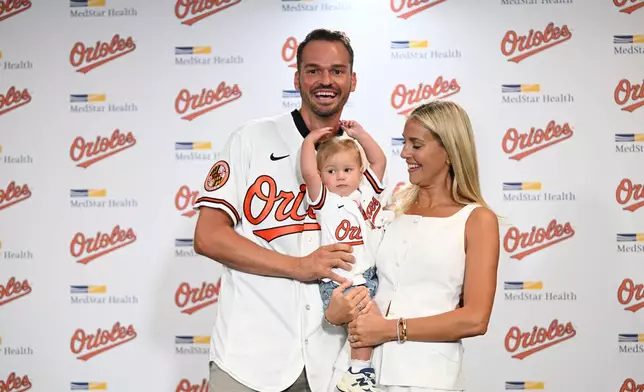 Former Baltimore Oriole Trey Mancini poses with his wife Sara Perlman and daughter Sadie after announcing his retirement as an Oriole during a news conference on Saturday, Sept. 19, 2026 in Baltimore. (AP Photo/Gail Burton)