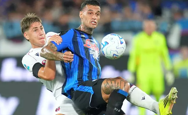 Atalanta's Gianluca Scamacca, right, fights for the ball with Bologna's Eivind Helland, left, during the Serie A soccer match between Atalanta and Bologna in Bergamo, Italy, Monday, Aug. 31 , 2026. (Spada/LaPresse via AP)