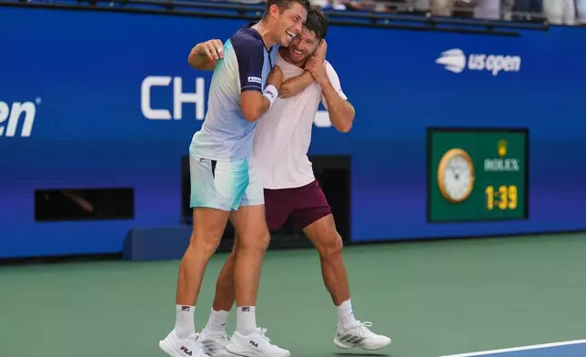 Neal Skupski, of Britain, left, celebrates with Christian Harrison, of the United States, right, after winning the men's doubles final of the U.S. Open tennis championships Kevin Krawietz, of Germany, and Tim Puetz, of Germany, Saturday, Sept. 12, 2026, in New York. (AP Photo/Kirsty Wigglesworth)