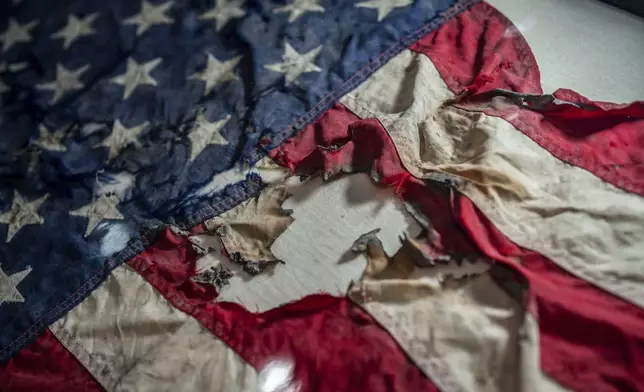 A badly damaged flag recovered from the World Trade Center debris is displayed at the Smithsonian's National Museum of American History, the nation's official repository for September 11 materials, in Washington, Thursday, Sept. 10, 2026. (AP Photo/J. Scott Applewhite)