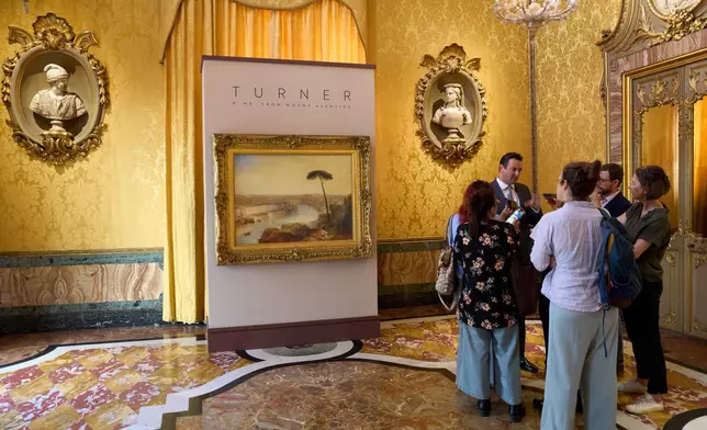 Julian Gascoigne, senior specialist in British paintings at Sotheby's London, explains J.M.W. Turner's 1836 painting "Rome, from Mount Aventine," left, estimated at around 50 million pounds ($67 million), to journalists in Rome, Tuesday, Sept. 29, 2026, during a press preview at Palazzo Rondinini ahead of its auction by Sotheby's in London on Dec. 9. (AP Photo/Domenico Stinellis)