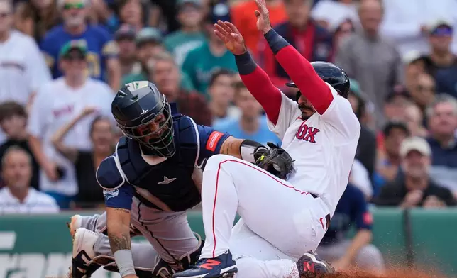 Seattle Mariners' Jhonny Pereda, left, tags out Boston Red Sox's Mickey Gasper, who was attempting to score on a single by Wilyer Abreu, during the first inning of a baseball game, Wednesday, Sept. 2, 2026, in Boston. (AP Photo/Charles Krupa)