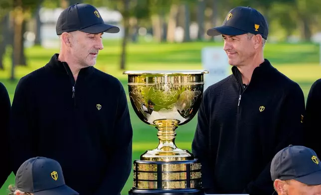 International team captain Geoff Ogilvy, of Australia, left, and player Adam Scott, of Australia, look at the Presidents Cup trophy during a team portrait prior to the start of the Presidents Cup golf tournament against the USA team at Medinah Country Club, Wednesday, Sept. 23, 2026, in Medinah, Ill. (AP Photo/Matt Slocum)