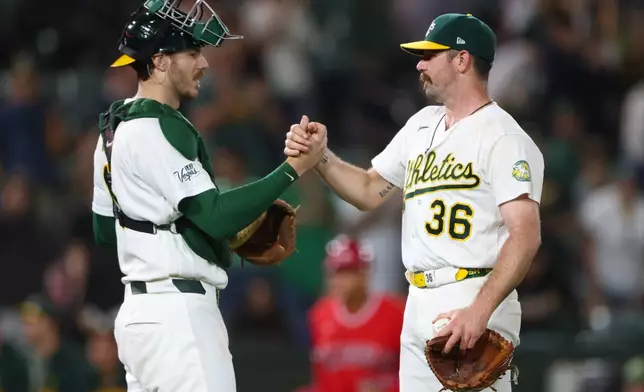 Athletics' Hogan Harris (36) celebrates with teammate Jonah Heim, left, after the Athletics win over the Los Angeles Angels in a baseball game Tuesday, Sept. 22, 2026, in West Sacramento, Calif. (AP Photo/Scott Marshall)