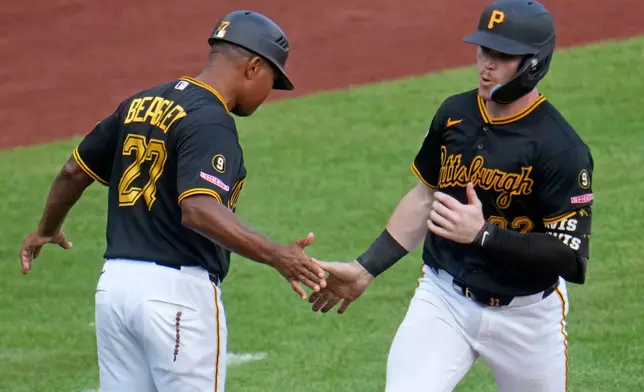 Pittsburgh Pirates' Henry Davis, right, rounds third to greetings from third base coach Tony Beasley after hitting a two-run home run off Milwaukee Brewers pitcher Aaron Ashby during the eighth inning of a baseball game in Pittsburgh, Thursday, Sept. 17, 2026. (AP Photo/Gene J. Puskar)