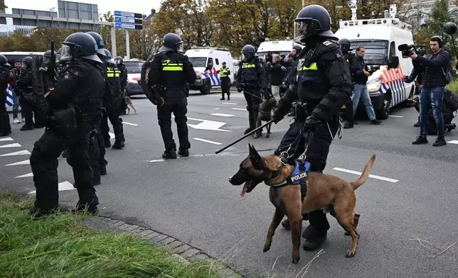 A Police officer with a dog guards during a far-right groups' protest against immigration and asylum policies, in The Hague, Netherlands, Saturday, Sept. 19, 2026. (AP Photo/Mouneb Taim)
