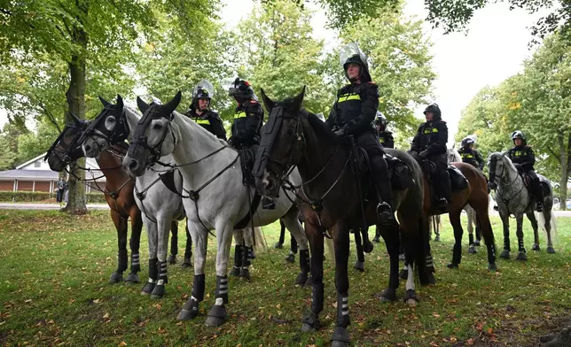 Police officers ride horses during a far-right groups' protest against immigration and asylum policies, in The Hague, Netherlands, Saturday, Sept. 19, 2026. (AP Photo/Mouneb Taim)