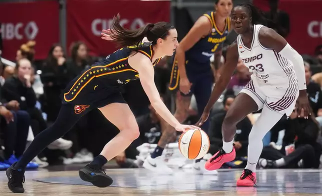 Indiana Fever's Caitlin Clark, left, drives as Toronto Tempo's Ornella Bankole (33) defends during the first half of a WNBA basketball game in Toronto, Friday, Sept. 18, 2026. (Nathan Denette/The Canadian Press via AP)