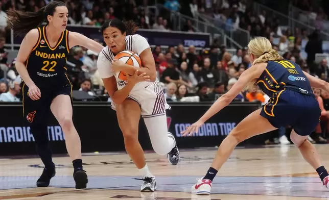 Toronto Tempo's Teonni Key, center, drives between Indiana Fever's Caitlin Clark (22) and Lexie Hull (10) during the first half of a WNBA basketball game in Toronto, Friday, Sept. 18, 2026. (Nathan Denette/The Canadian Press via AP)