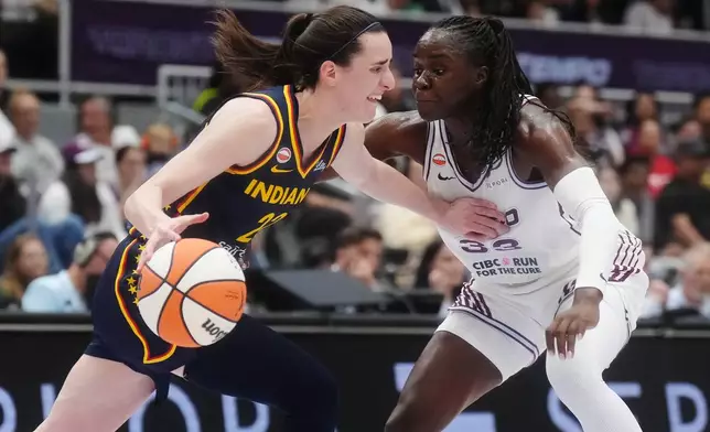Indiana Fever's Caitlin Clark (22) drives as Toronto Tempo's Ornella Bankole (33) defends during first half WNBA basketball action in Toronto on Friday, Sept. 18, 2026. (Nathan Denette/The Canadian Press via AP)