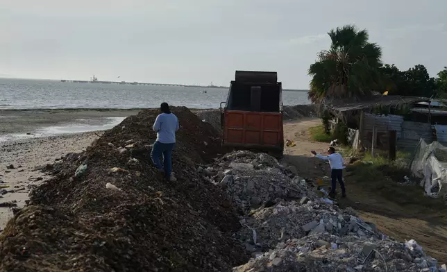 Workers build a barricade to help keep water out of their town as Hurricane Polo approaches in Puerto San Carlos, Baja California Sur state, Mexico, Sunday, Sept. 27, 2026. (AP Photo/Eduardo Verdugo)