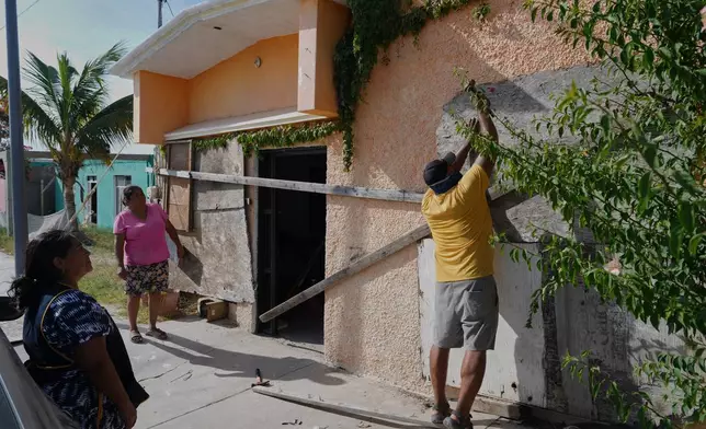 A man boards up a house's windows as Hurricane Polo approaches in Puerto San Carlos, Baja California Sur state, Mexico, Sunday, Sept. 27, 2026. (AP Photo/Eduardo Verdugo)