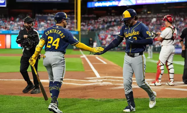 Milwaukee Brewers' Brice Turang, right, celebrates hits a home run off of Philadelphia Phillies pitcher Aaron Nola with teammate William Contreras during the first inning of a baseball game, Wednesday, Sept. 23, 2026, in Philadelphia. (AP Photo/Matt Rourke)