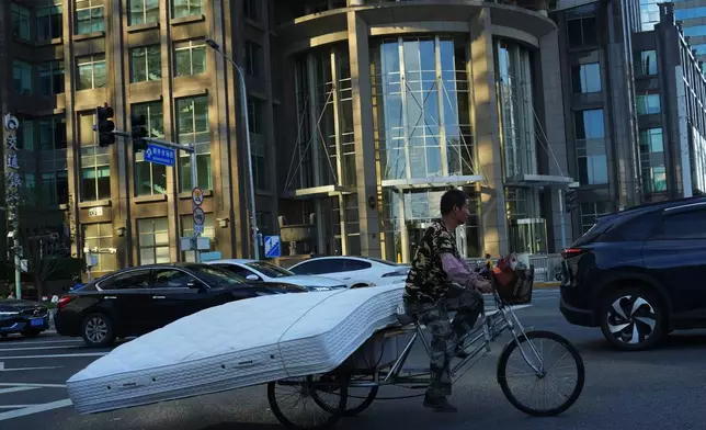 A man rides a tricycle to carry a mattress in Beijing, Saturday, Aug. 29, 2026. (AP Photo/Achmad Ibrahim)