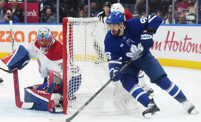 Toronto Maple Leafs' Kirill Marchenko (86) tries a wraparound on Montreal Canadiens goaltender Jakub Dobes (75) during the second period of an NHL hockey game against the Montreal Canadiens in Toronto, Tuesday, Sept. 29, 2026. (Nathan Denette/The Canadian Press via AP)