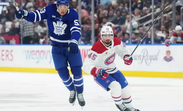 Toronto Maple Leafs' Easton Cowan (53) jumps out of the way of Montreal Canadiens' Alexandre Carrier (45) during the second period of an NHL hockey game against the Montreal Canadiens in Toronto, Tuesday, Sept. 29, 2026. (Nathan Denette/The Canadian Press via AP)