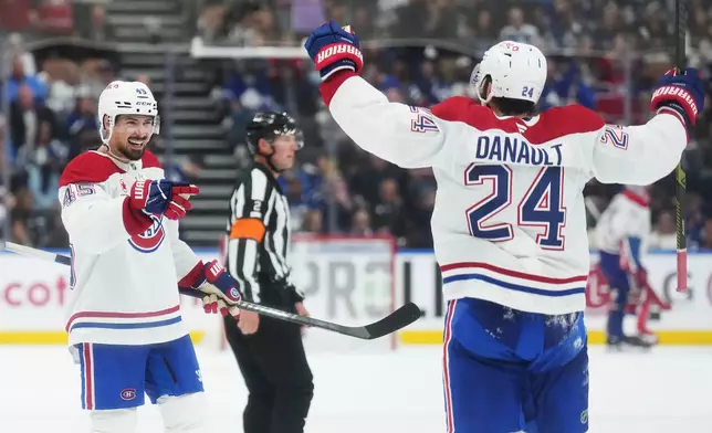 Montreal Canadiens' Alexandre Carrier (45) celebrates his goal against the Toronto Maple Leafs with Phillip Danault (24) during the third period of an NHL hockey game against the Montreal Canadiens in Toronto, Tuesday, Sept. 29, 2026. (Nathan Denette/The Canadian Press via AP)