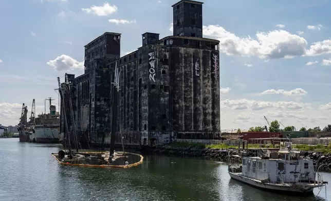 Debris of the Victory Chimes and the Pilot floats next to abandoned Red Hook Grain Terminal in the Henry Street Basin, Wednesday, Aug. 26, 2026, in the Brooklyn borough of New York. (AP Photo/Yuki Iwamura)