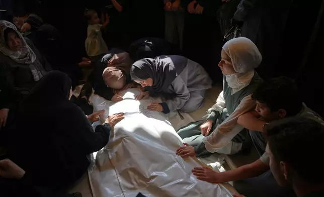 Palestinian women mourn over the body of Muhammad Yazouri, who was killed in an Israeli airstrike Thursday night, ahead of his funeral in Khan Younis, southern Gaza Strip, Friday, Sept.11, 2026. (AP Photo/Jehad Alshrafi)