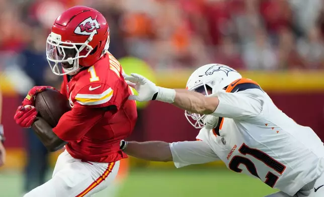 Kansas City Chiefs wide receiver Xavier Worthy (1) is pushed out of bounds by Denver Broncos cornerback Riley Moss (21) during the first half of an NFL football game Monday, Sept. 14, 2026, in Kansas City, Mo. (AP Photo/Charlie Riedel)