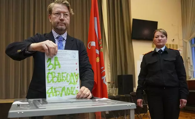 Yabloko party leader Nikolai Rybakov casts a ballot with a writing in Russian reading "For freedom" during the parliamentary election in St. Petersburg, Russia, Sunday, Sept. 20, 2026. (AP Photo/Dmitri Lovetsky)