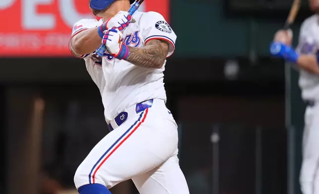 Texas Rangers' Cody Freeman follows through on a swing while driving in Jake Burger with a run against the Athletics during the second inning of a baseball game Monday, Aug. 31, 2026, in Arlington, Texas. (AP Photo/Julio Cortez)