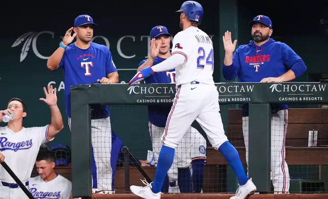 Texas Rangers' Brandon Nimmo (24) is greeted near the dugout after scoring on a single by Elias DÌaz during the second inning of a baseball game against the Athletics Monday, Aug. 31, 2026, in Arlington, Texas. (AP Photo/Julio Cortez)