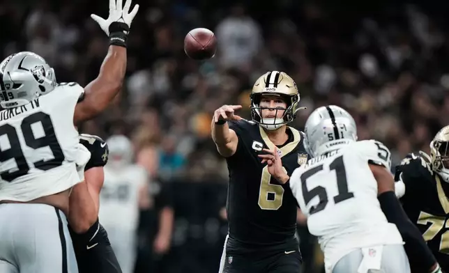New Orleans Saints quarterback Tyler Shough (6) throws a pass under pressure from Las Vegas Raiders defensive tackle Thomas Booker IV (99) and defensive end Malcolm Koonce (51) during the second half of an NFL football game in New Orleans, Sunday, Sept. 27, 2026. (AP Photo/Gerald Herbert)