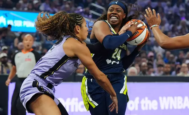 Golden State Valkyries guard Veronica Burton, left, fouls Dallas Wings guard Arike Ogunbowale (24) during the first half of a WNBA basketball first-round playoff game Sunday, Sept. 27, 2026, in San Francisco. (AP Photo/Alan Greth)