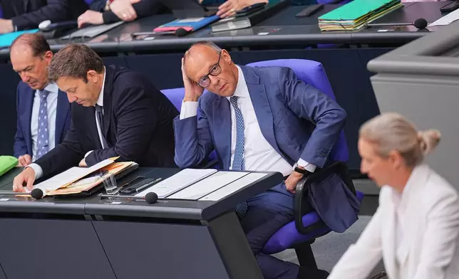 German Chancellor Friedrich Merz looks at federal chairwoman and parliamentary group leader of the AfD Alice Weidel as she opens the general debate as part of the budget deliberations in the Bundestag, in Berlin, Wednesday Sept. 9, 2026 (Michael Kappeler/dpa via AP)